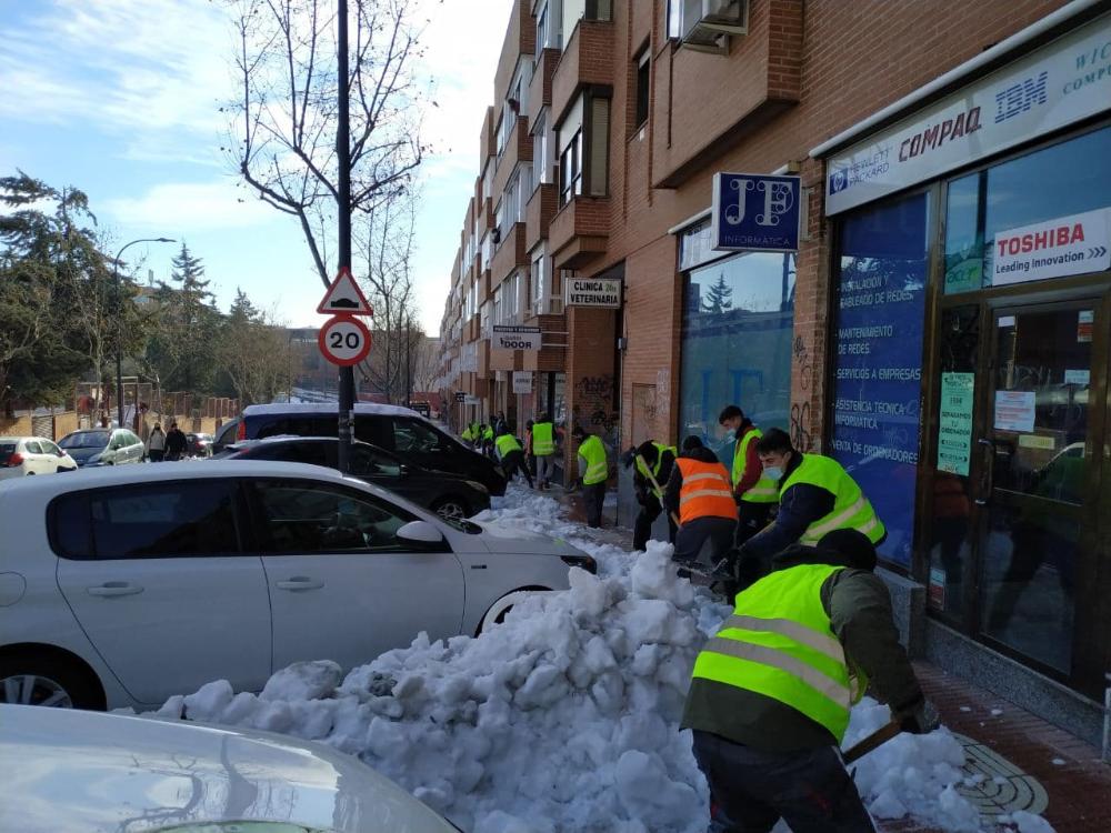 Operarios liberando de nieve de las aceras en San Sebastián de los Reyes